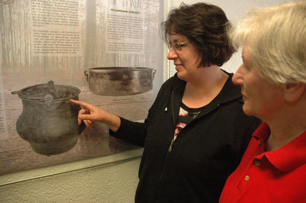 Die Schellerter Heimatpflegerinnen Heike Klapprott und Gerda Mayer erläutern die Fundgeschichte zu einem Römischen Kupferkessel, der im 19. Jahrhundert zwischen Wöhle und Nettlingen entdeckt wurde. Foto: Mierzowsky
