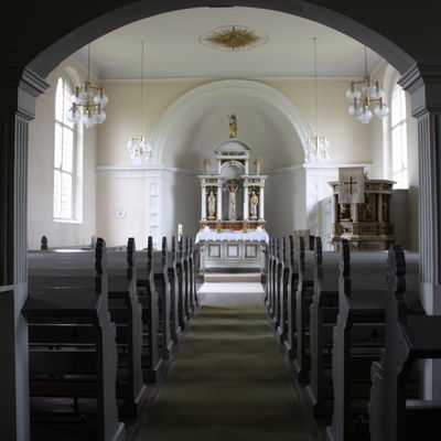 Blick durch das Kirchenschiff auf im Stil der Neorenaissance gestalteten Altar und Kanzel